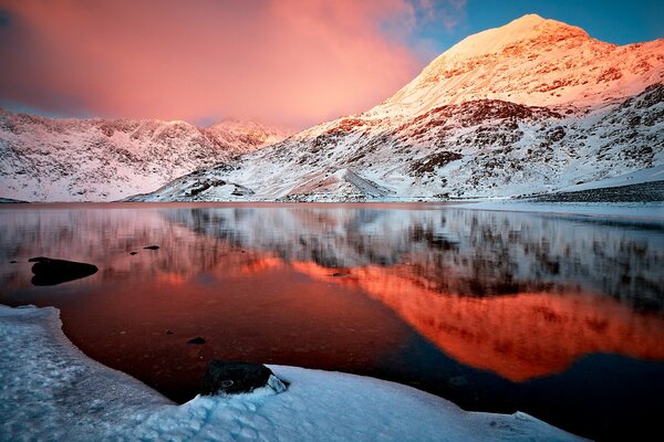 La superficie del lago de montaña refleja místicamente el cielo