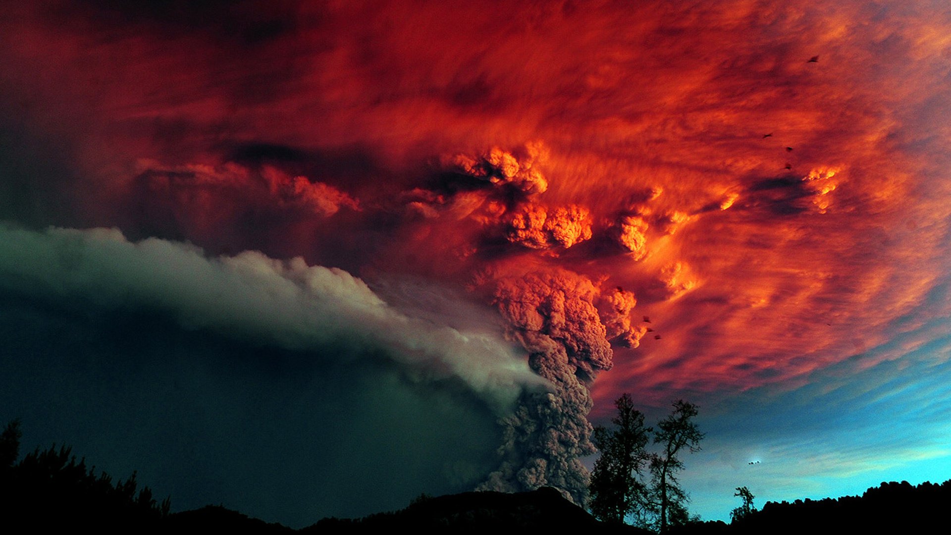 volcán erupción árboles cenizas cielo rojo