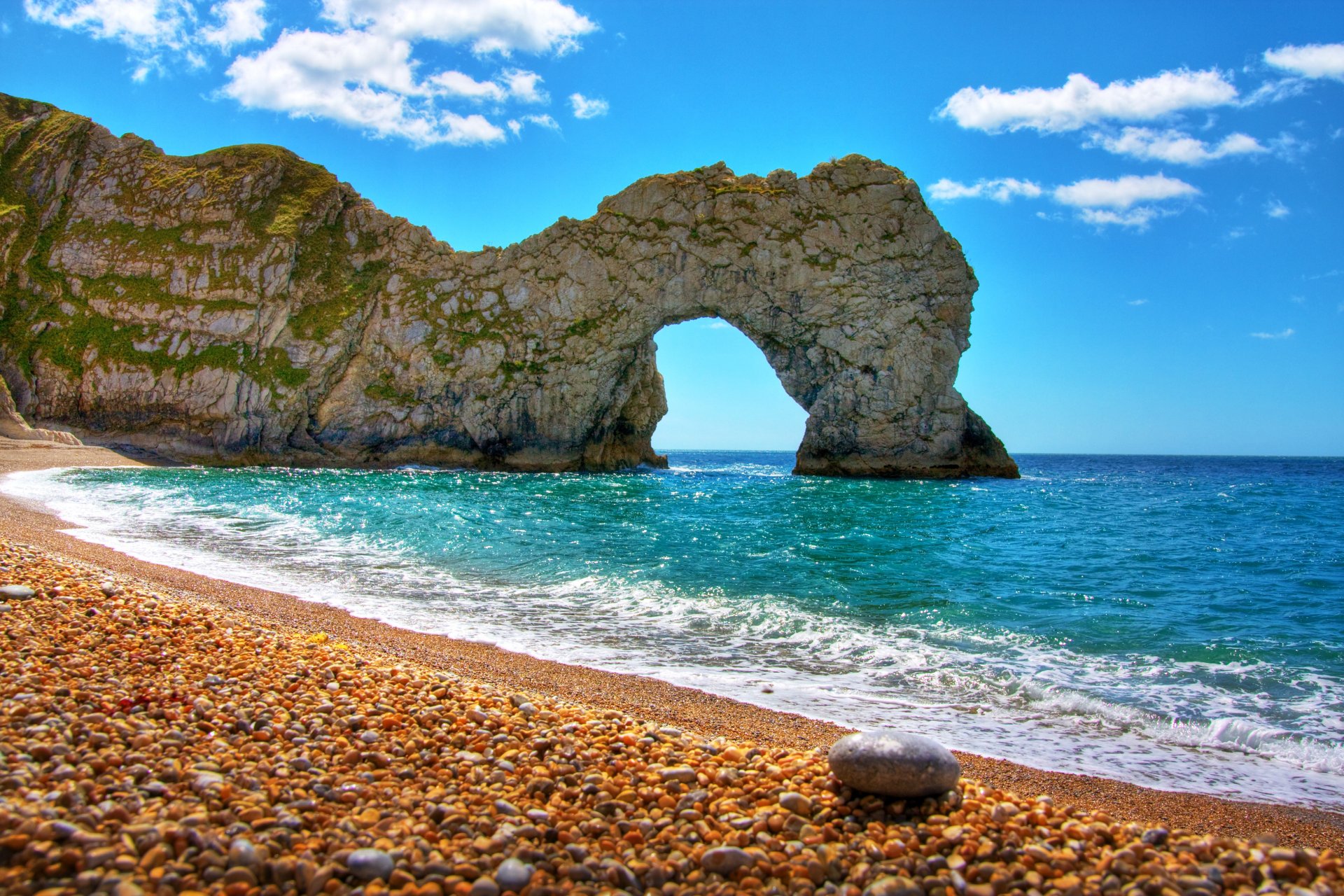 natura mare roccia arco spiaggia ciottoli cielo nuvole giornata limpida