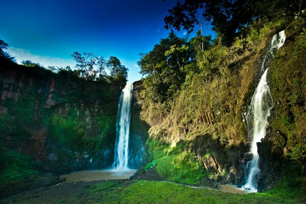 Waterfall on a tropical meadow with a lake