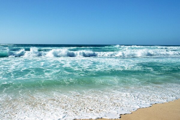 Plage sur la mer avec des vagues sur le sable