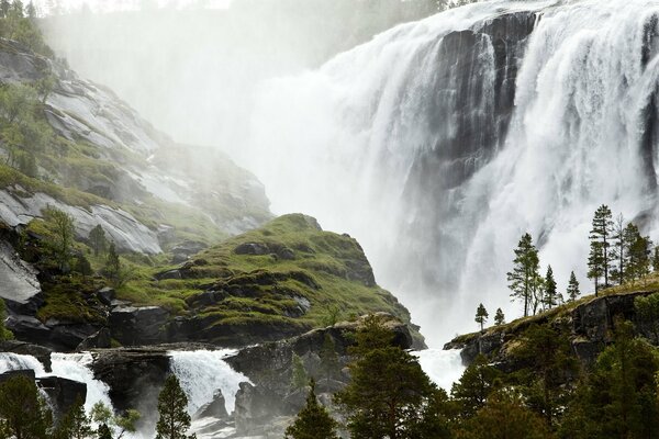 Cascade près des montagnes vertes et des arbres