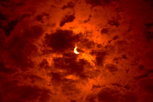 Éclipse solaire partielle dans les nuages rouges