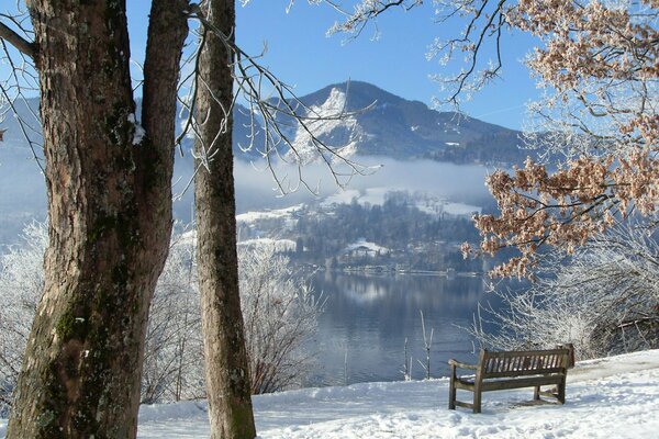 Eine Bank am Ufer eines schneebedeckten Sees