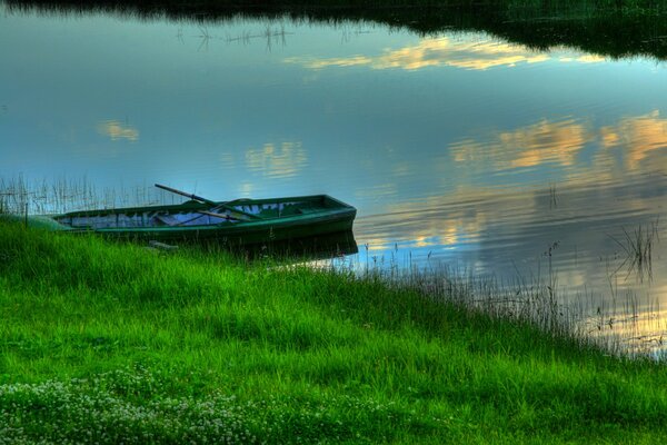 There is a lonely boat by the green shore