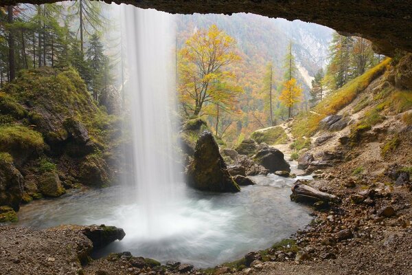 Поток горного водопада среди камней тропинка в лесу