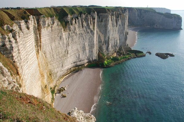 Cliff above the sea, layered rocks of the mountain slope