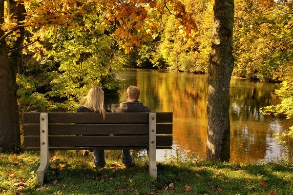 Ein Mann und ein Mädchen auf einem Spaziergang im goldenen Herbst Park