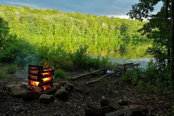 Lagerfeuer auf dem Hintergrund eines tiefen Sees