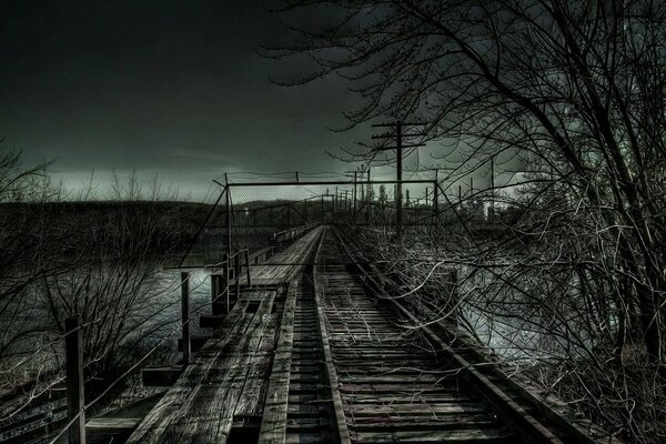 The gloomy railway by the river