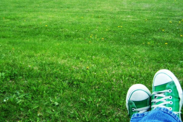 Photo de pieds en baskets lumineuses sur la pelouse