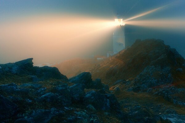 Faro notturno attraverso le rocce