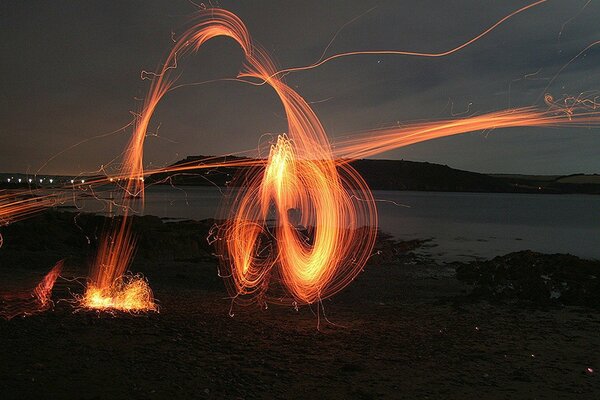 Image fantastique d une étincelle de feu de camp sur la plage de nuit