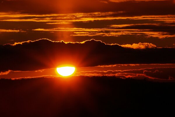 Crimson sunset. The sun is behind the clouds