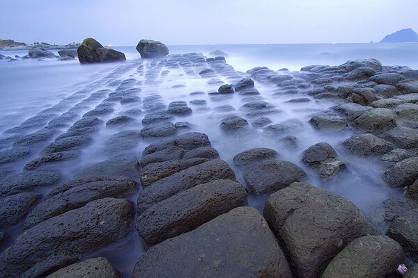 Spiaggia rocciosa avvolta dalla nebbia