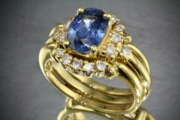 Gold ring with a large blue stone and a scattering of diamonds