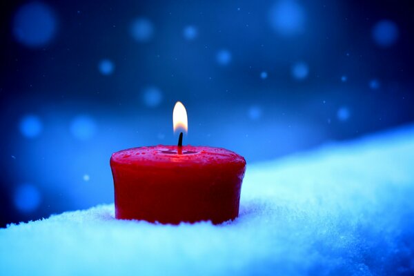 Photo red candle in the snow