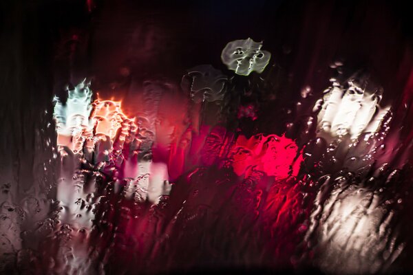 Luces a través de la noche de chorro de agua de cristal