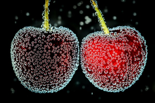 Cerezas maduras en burbujas en el agua