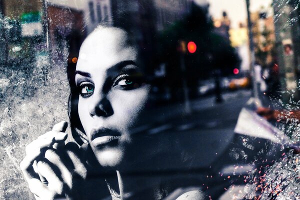 Portrait of a girl looking at the city through the glass of a cafe