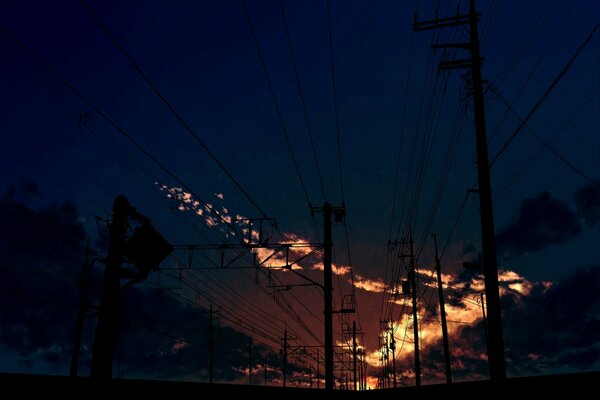 Puesta de sol ardiente entre los postes de energía