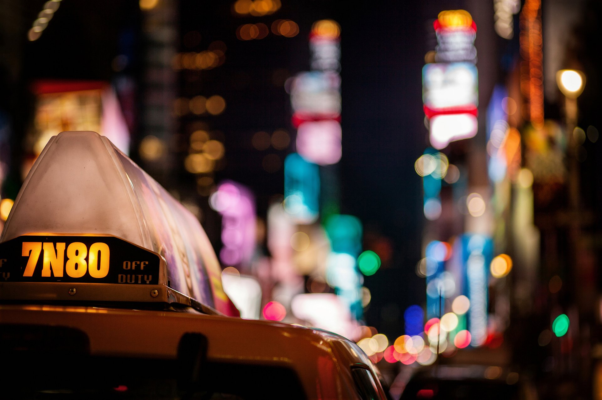 taxi auto città notte grattacieli luci multicolore bokeh