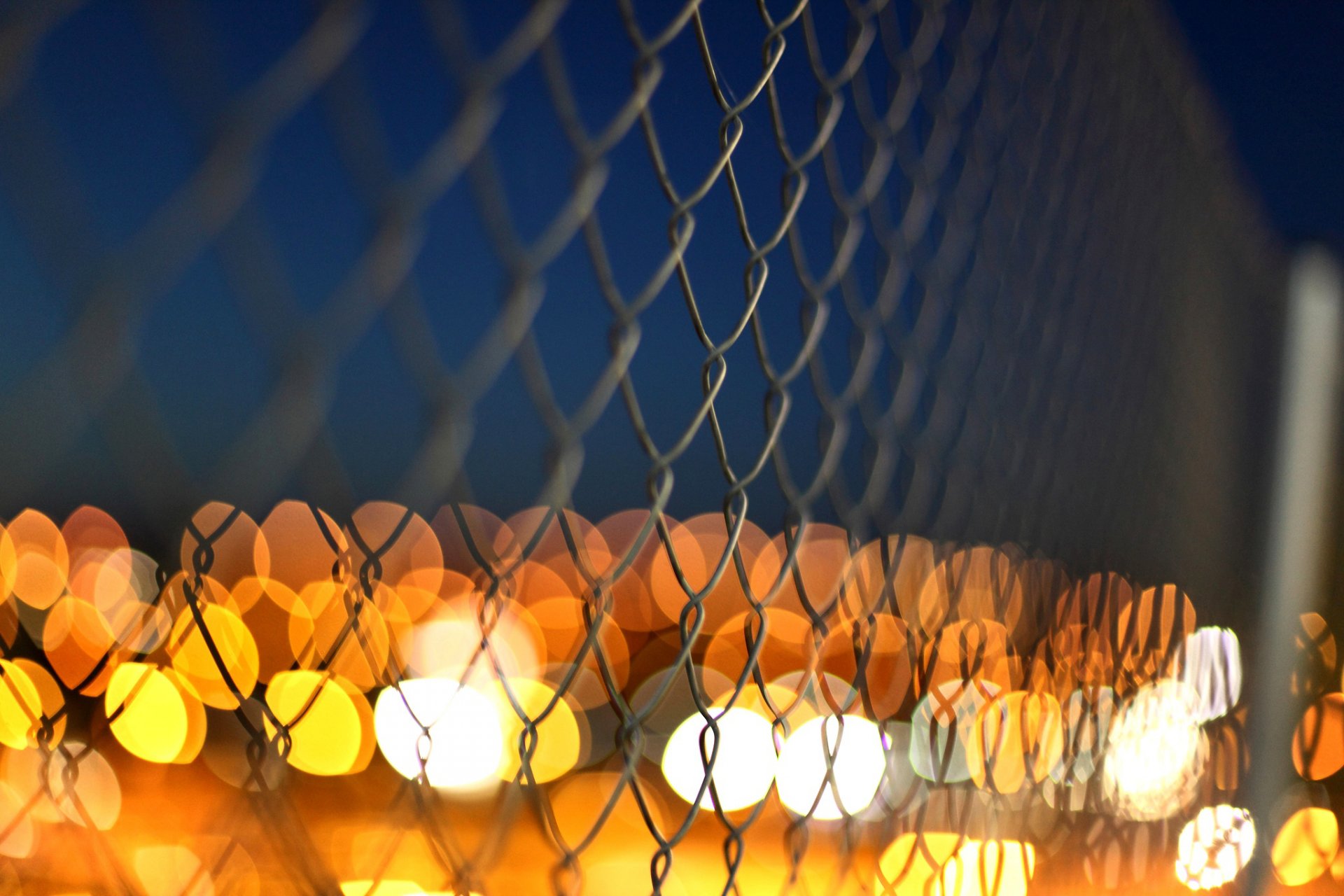 fence mesh metal fence macro lights yellow orange blur