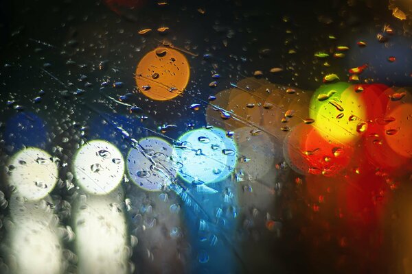 Multicolored raindrops on the glass