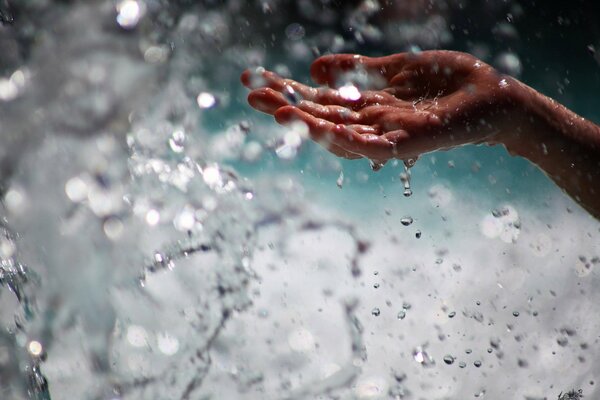 Wassertropfen werden nass auf die Hand gegeben