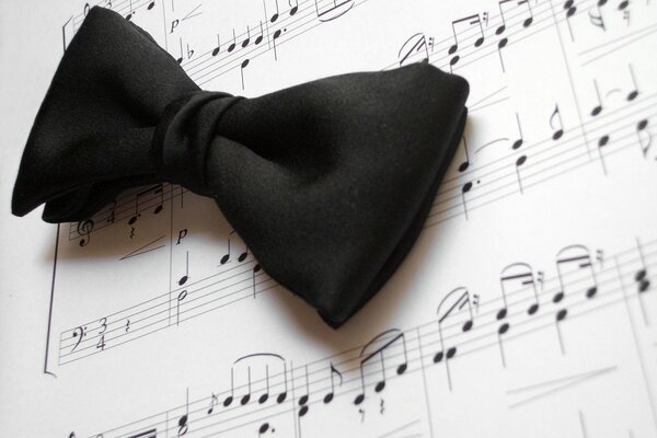 The bow tie is on the sheet music