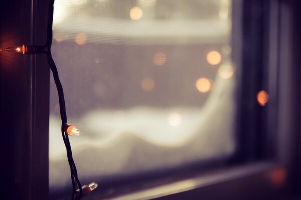 Nieve en la ventana y luces de cadena