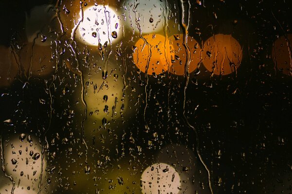 Gotas de lluvia sobre vidrio amarillo