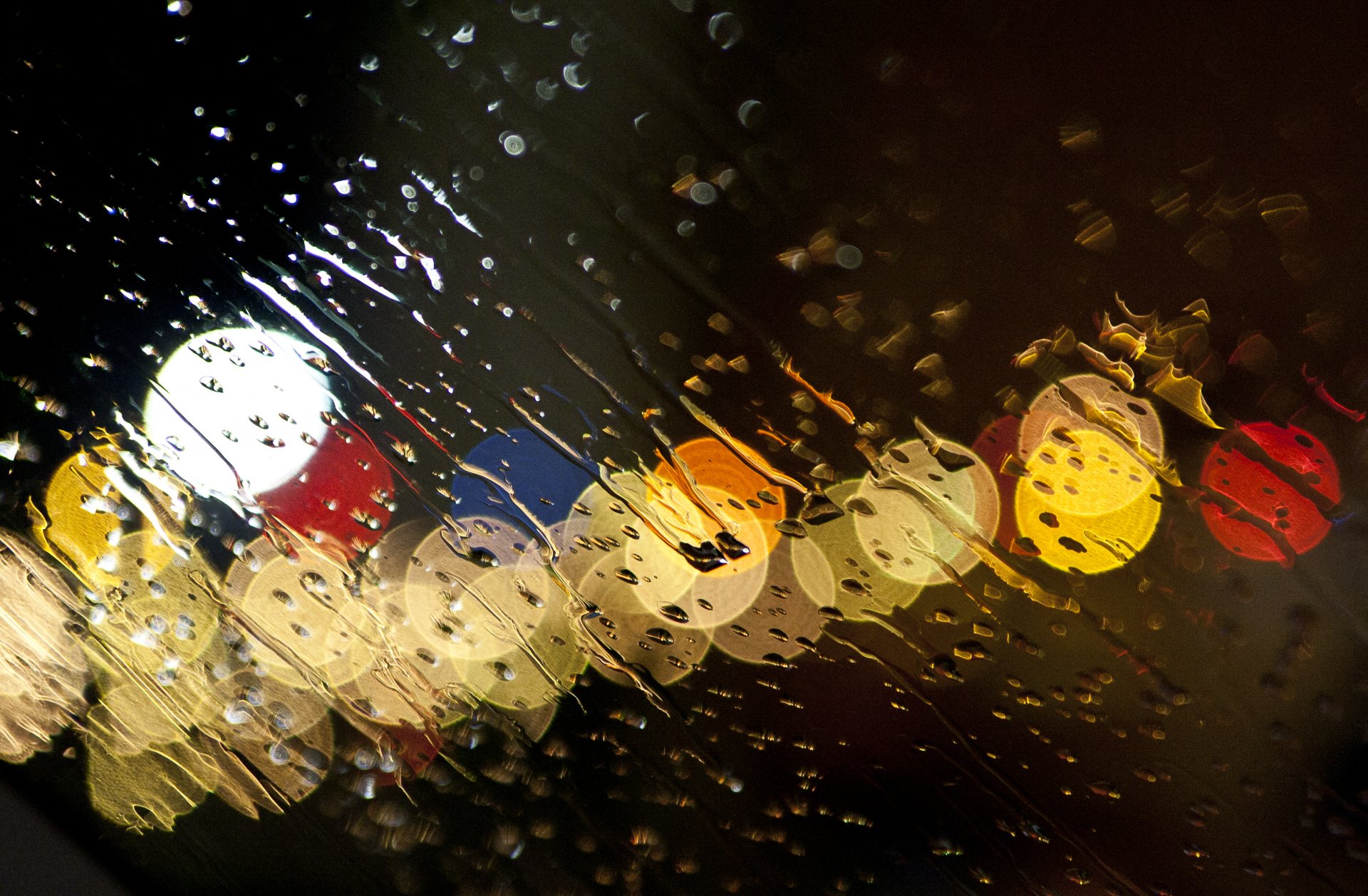 rain downpour glass water drops streams lights glass sprayed with water in the evening sky canon rebel xt