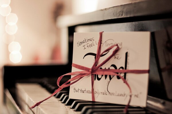 A letter with a bow on the piano keys