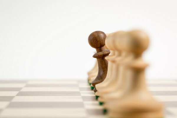 Wooden pawns on a chessboard in macro photo