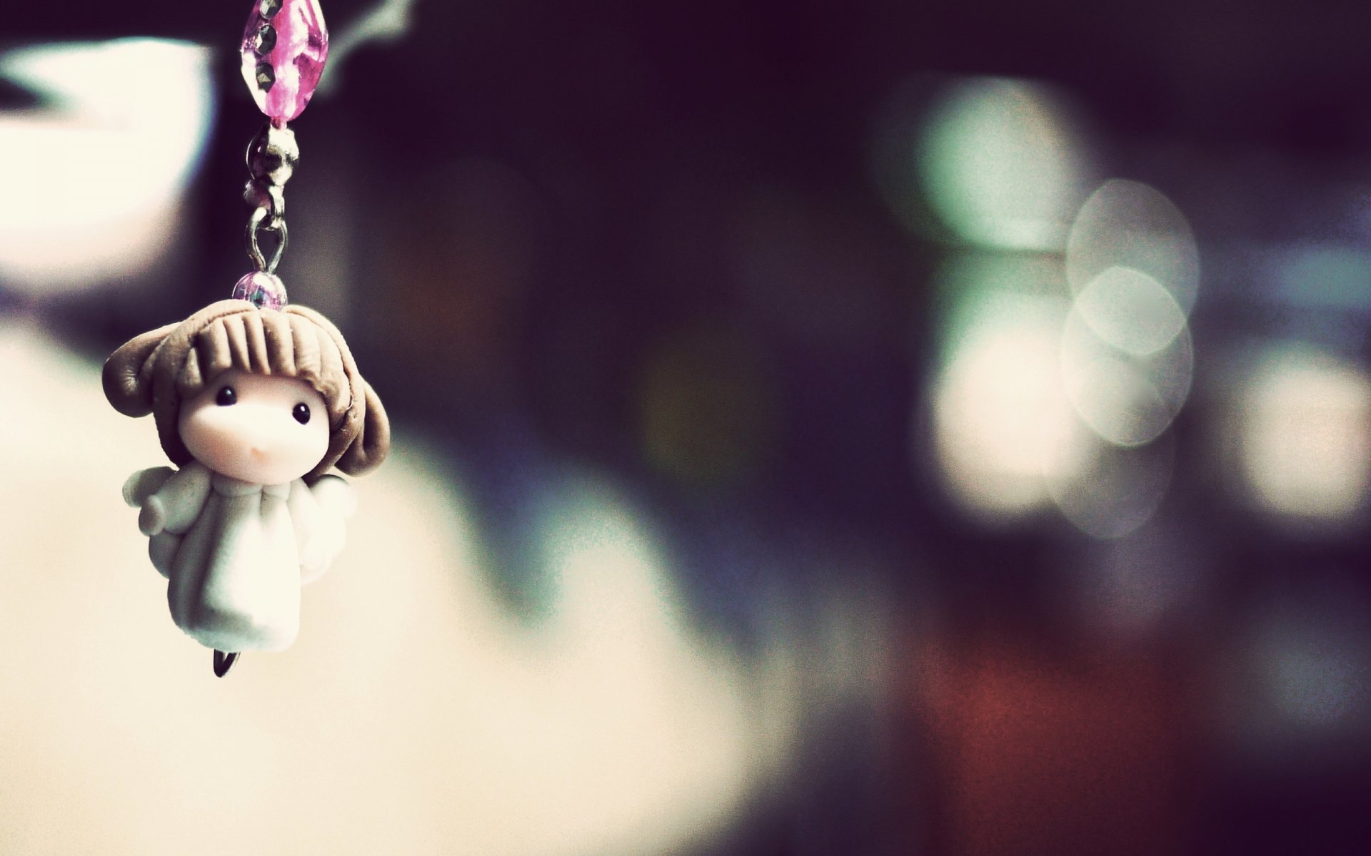 close up photo keychain figurine girl angel reflections bokeh