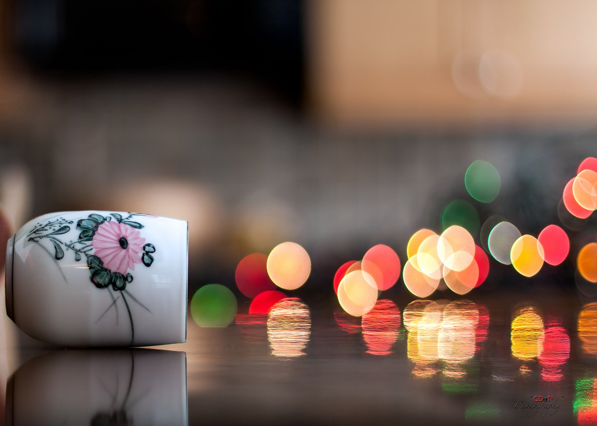 close up cup vase sideways bokeh light reflection