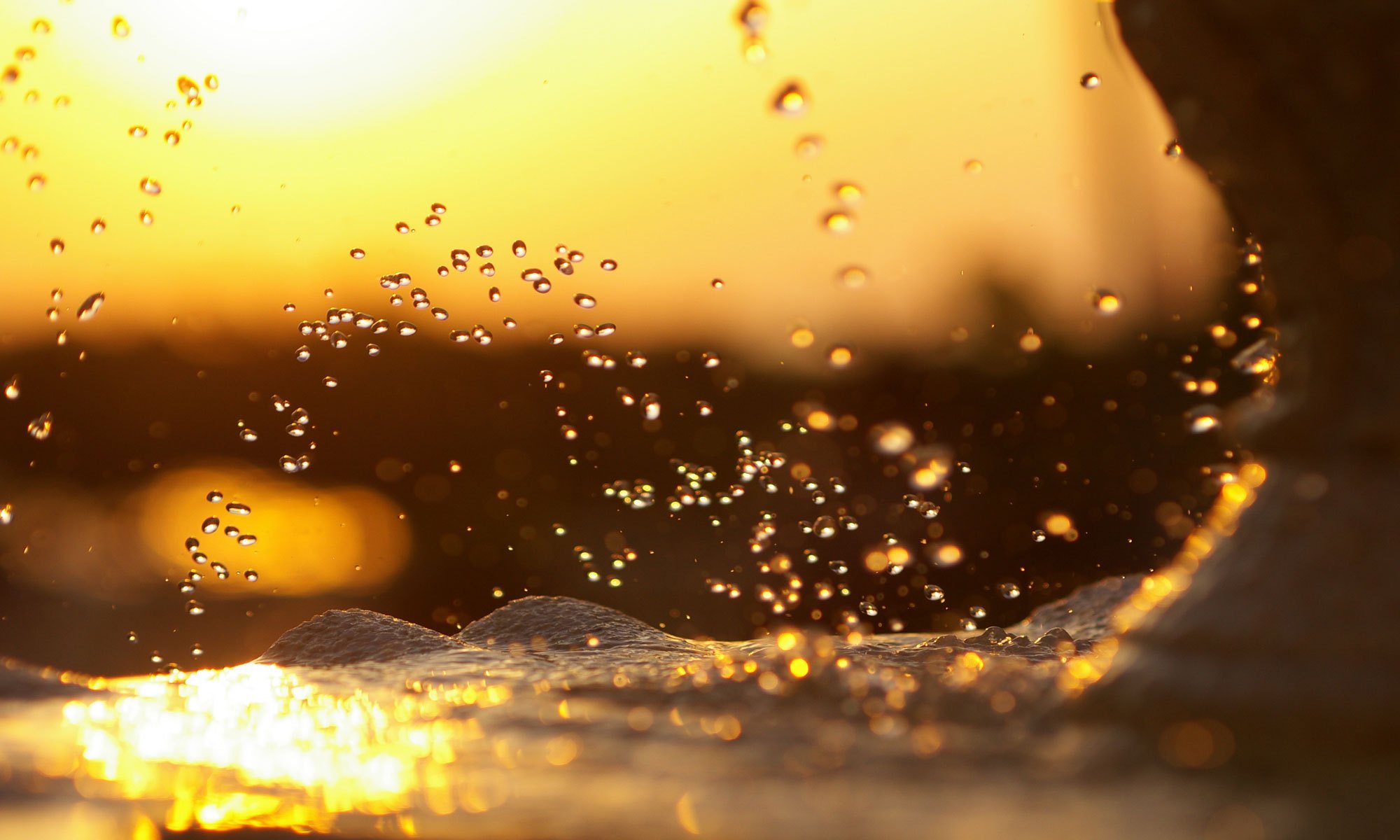 wasser spritzer welle meer schaum spritzer tropfen bei sonnenuntergang himmel sonne blendung abend