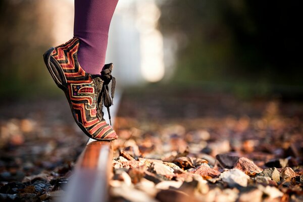 Piedi in scarpe luminose e collant viola