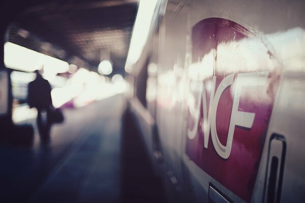 Uomo con valigetta accanto al treno della metropolitana in immagine sfocata andare via