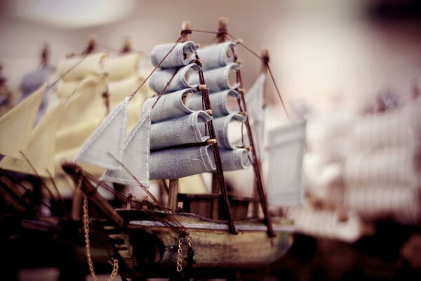 Modèle de bateau en bois avec des mâts et des voiles sur fond flou