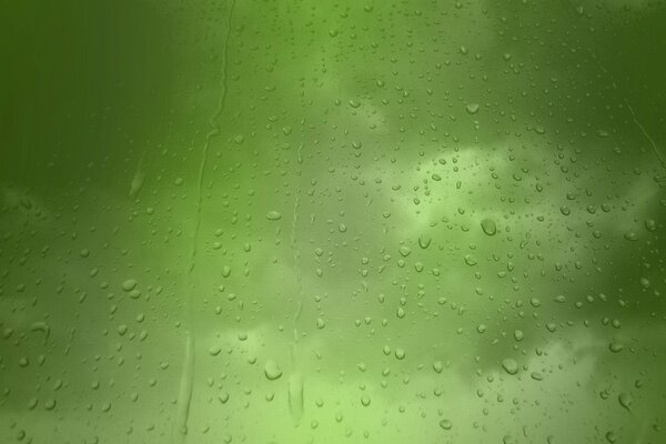 Raindrops on glass on a green background