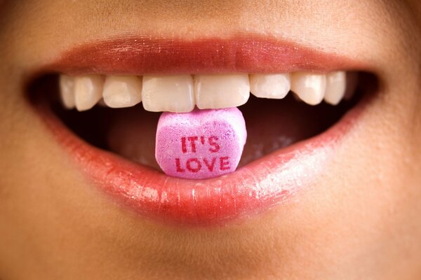 Candy with the inscription in the girl s mouth