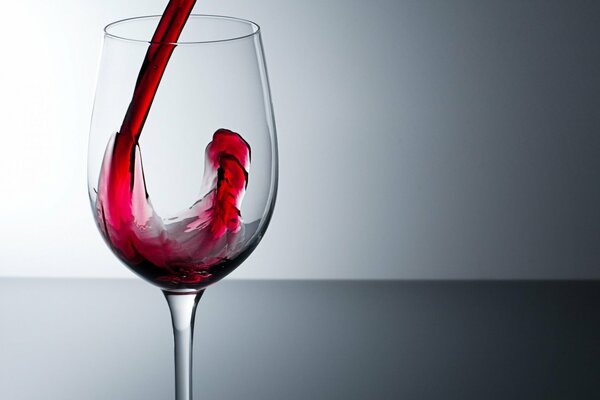 Un verre solitaire dans lequel le vin rouge est versé