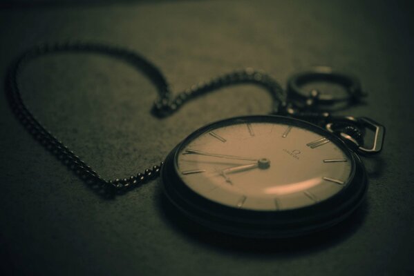 Reloj de bolsillo con cadena. Foto retro sobre fondo oscuro