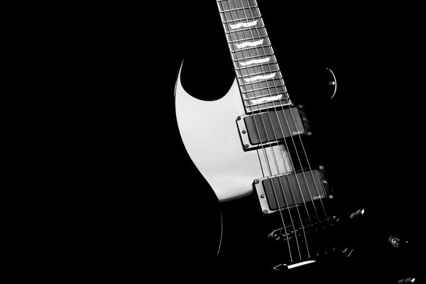 Guitare noire avec des reflets sur fond noir