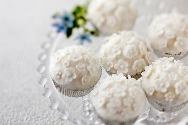 White cupcakes on a background of flowers