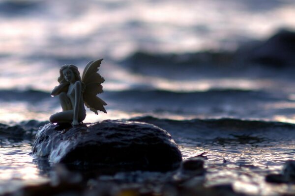 Macro shooting of a fairy figurine on a stone