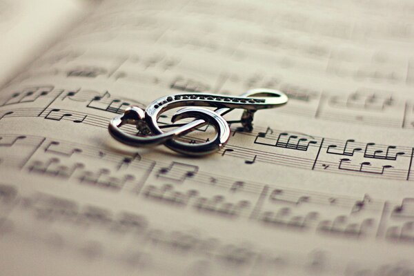 A brooch in the form of a treble clef on a music book