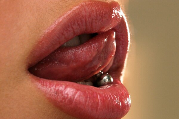 Labios femeninos y lengua con piercings grandes